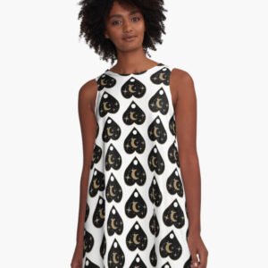 Front view of woman wearing white A-line dress with repeating black and gold planchette pattern featuring crescent moons and stars.