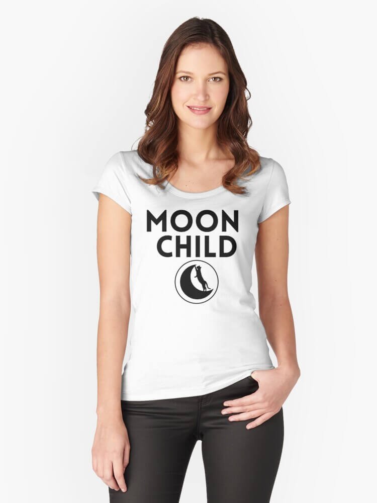 Person wearing a white fitted scoop-neck t-shirt with bold black text that reads ‘Moon Child’ above a crescent moon and cat graphic, standing against a plain white background.